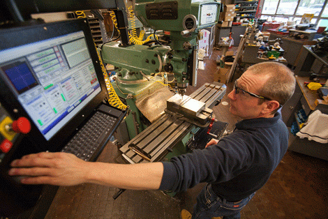 Man wearing safety glasses working with equipment in the machine shop